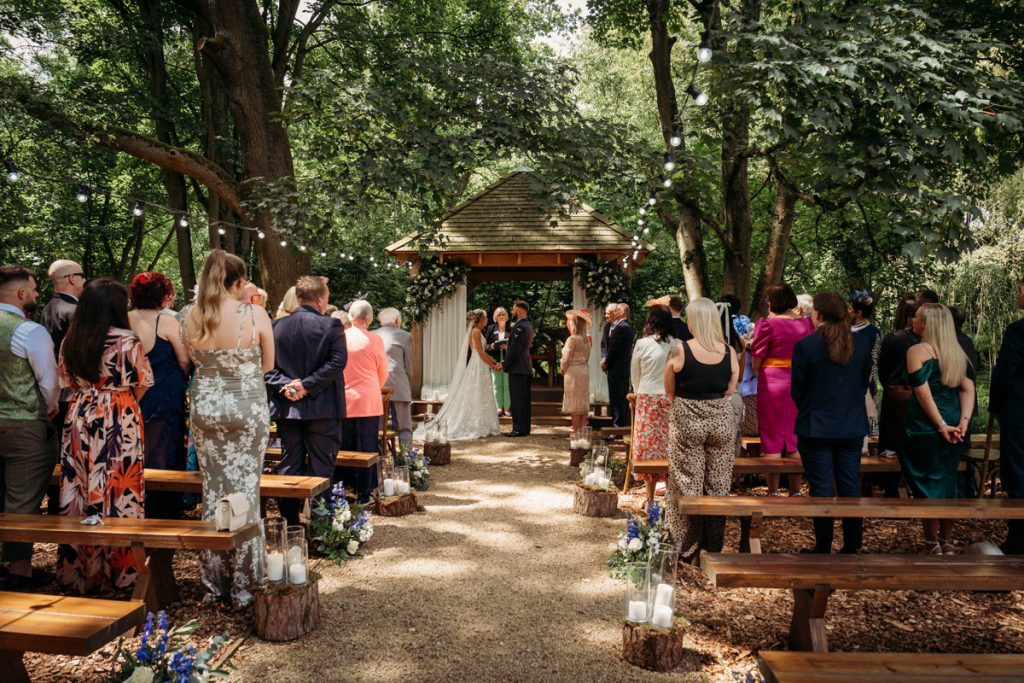 Outdoor wedding ceremony in forest setting.