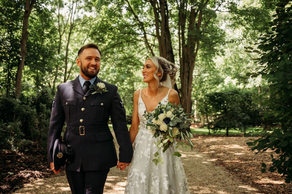 Couple in wedding attire walking in forest