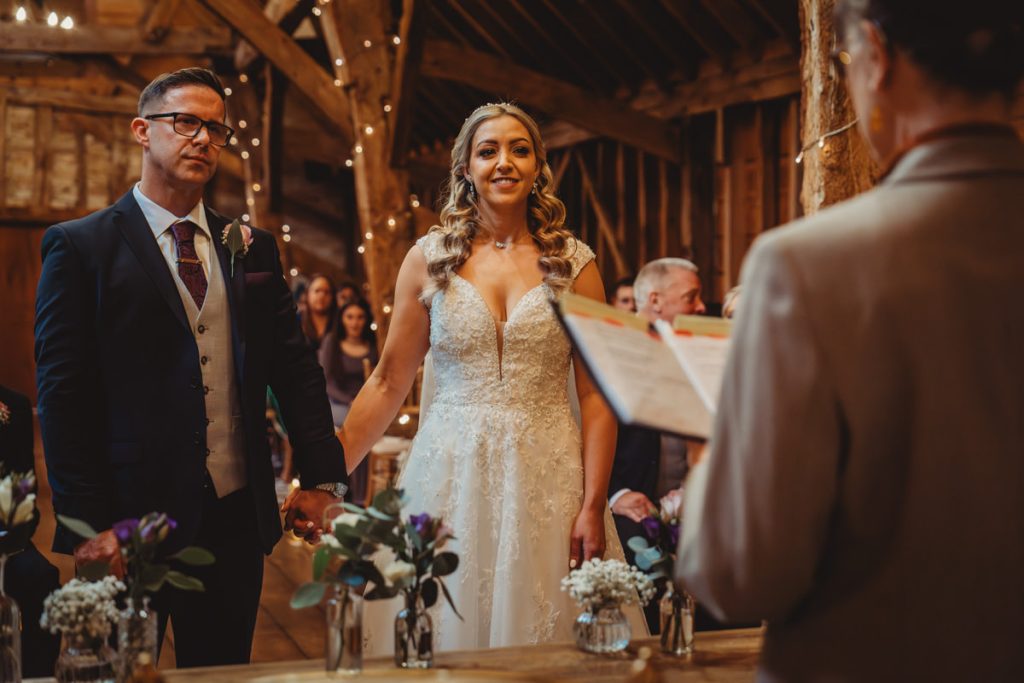 Couple exchanging vows in rustic wedding ceremony.