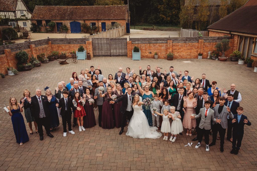 Large wedding group posing outdoors.