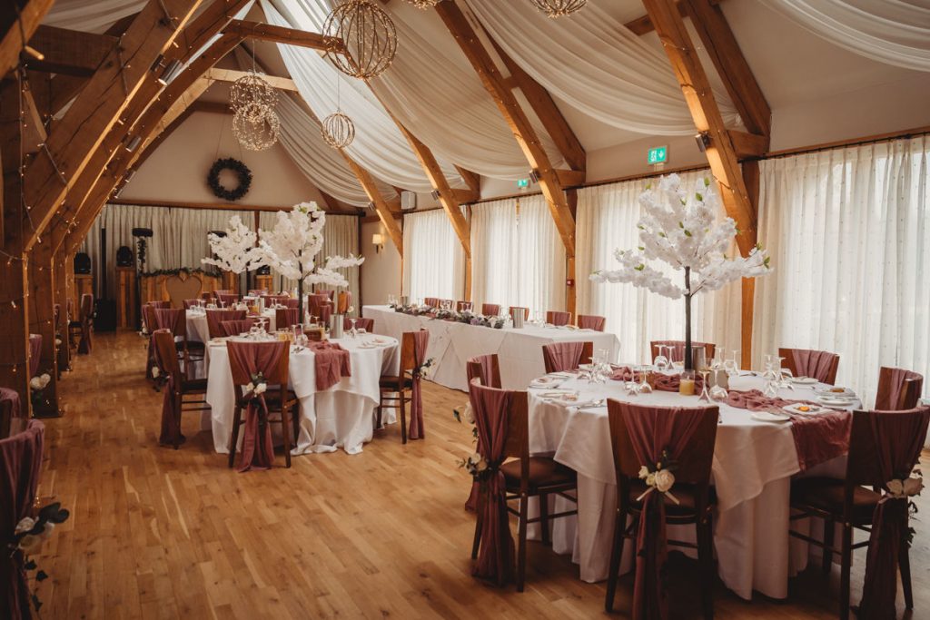 Elegant wedding reception hall with decorated tables.