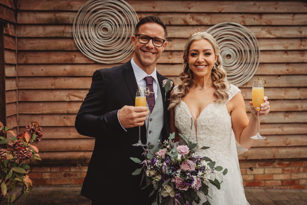 Bride and groom celebrating with champagne and flowers.