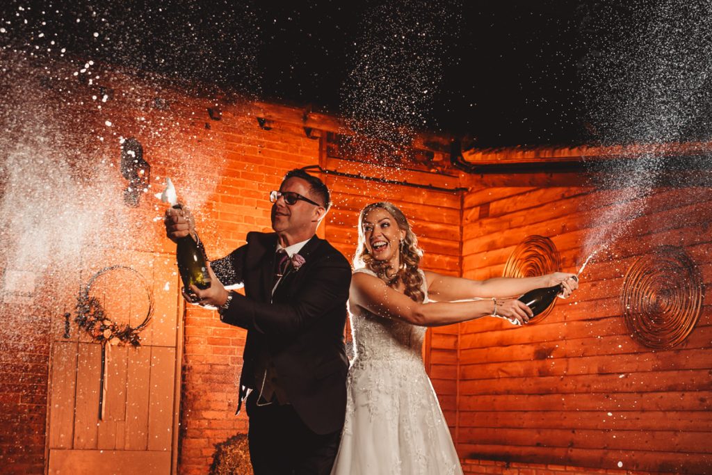 Bride and groom spraying champagne joyfully
