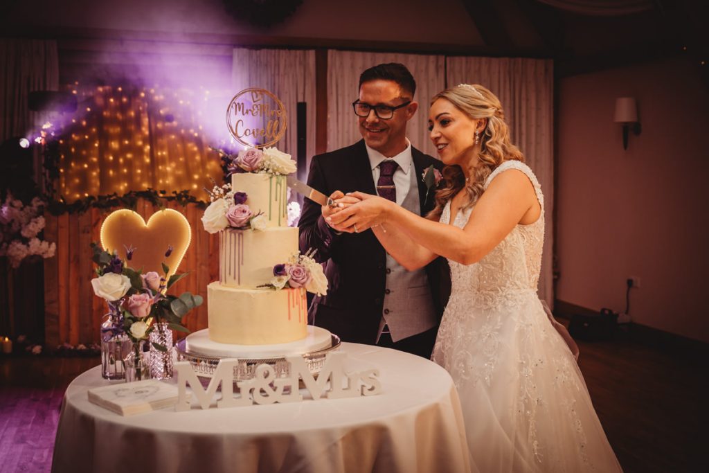 Bride and groom cutting wedding cake