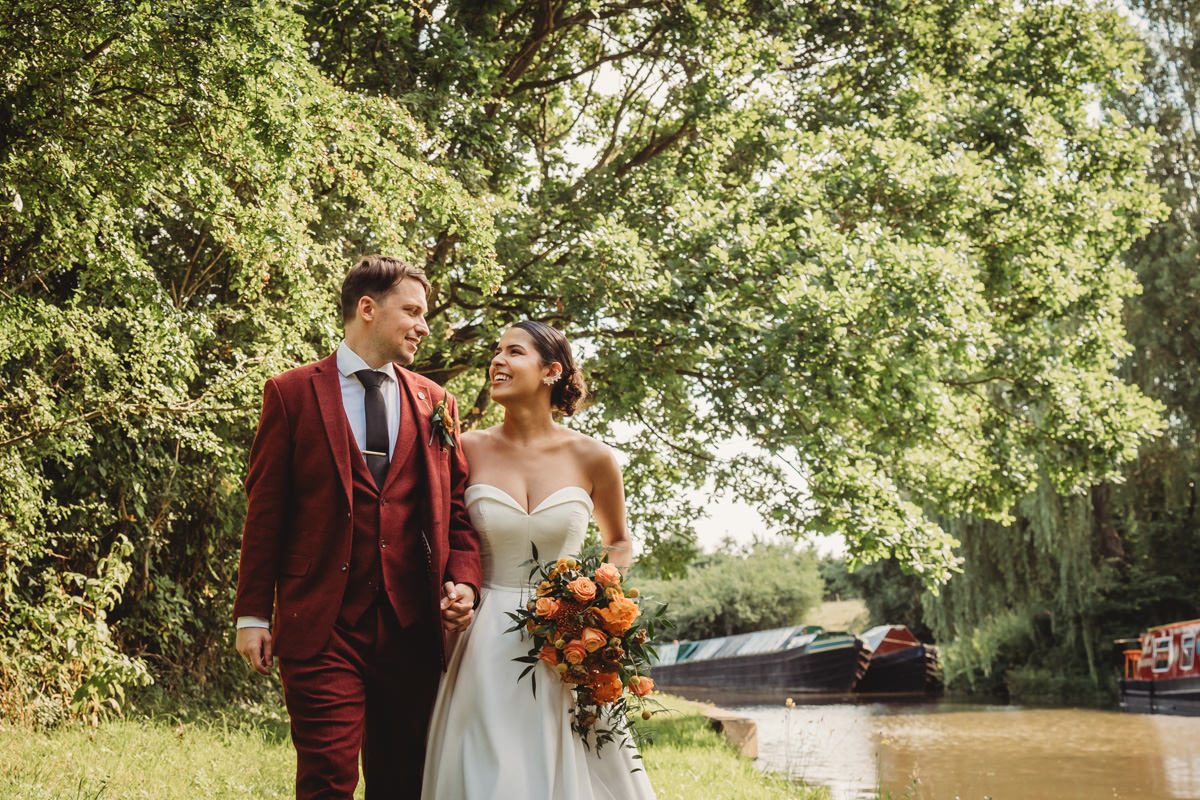 Couple walking by canal on wedding day