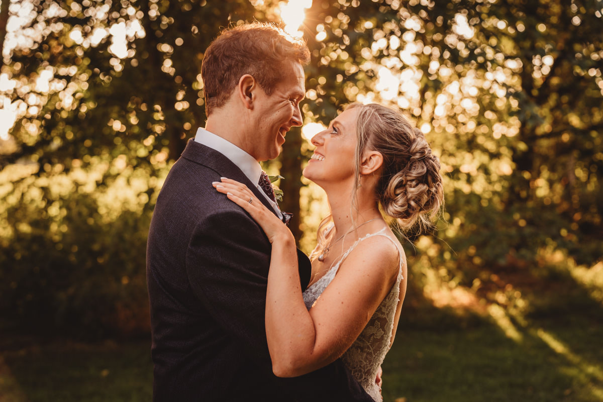 Couple embracing outdoors during sunset.