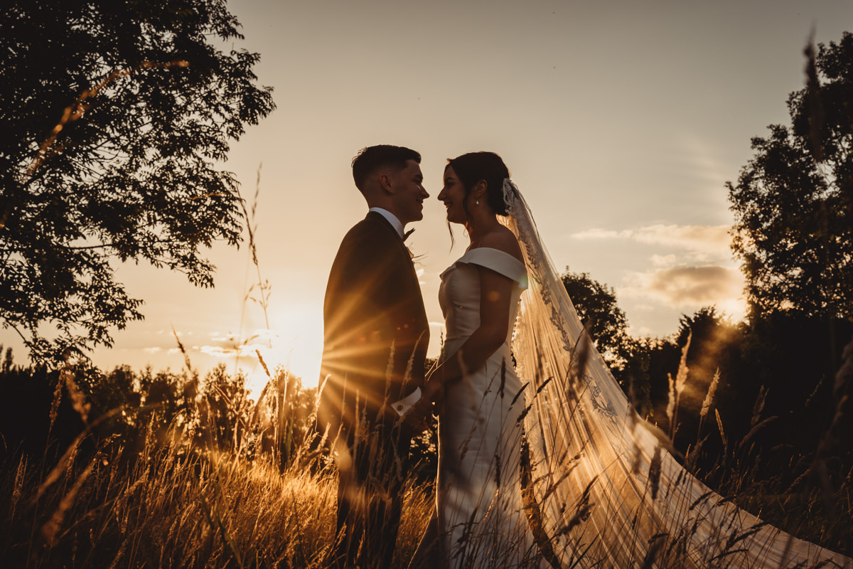 Silhouetted couple at sunset wedding scene