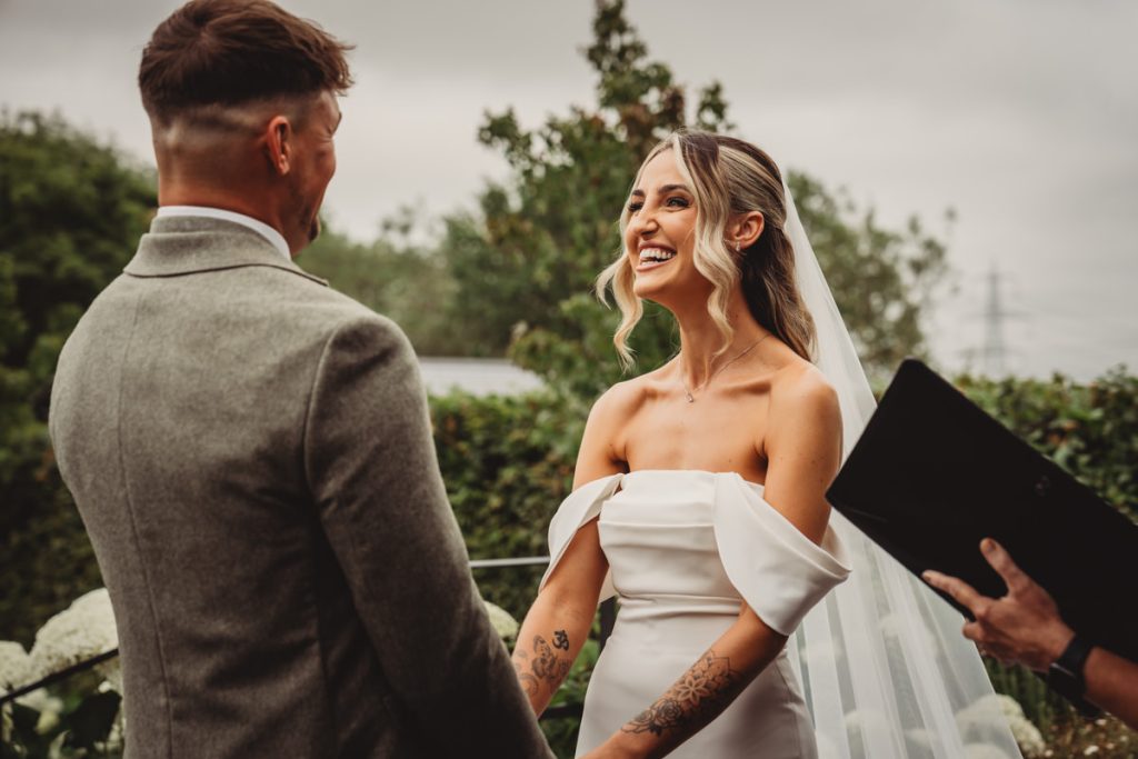 Bride and groom exchanging vows outdoors at wedding.