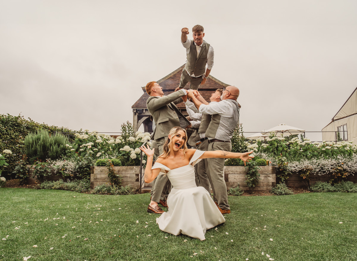 Wedding party fun pose in garden setting