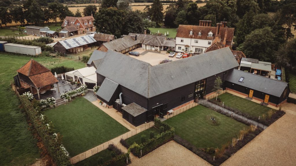 Aerial view of rustic countryside buildings and gardens.