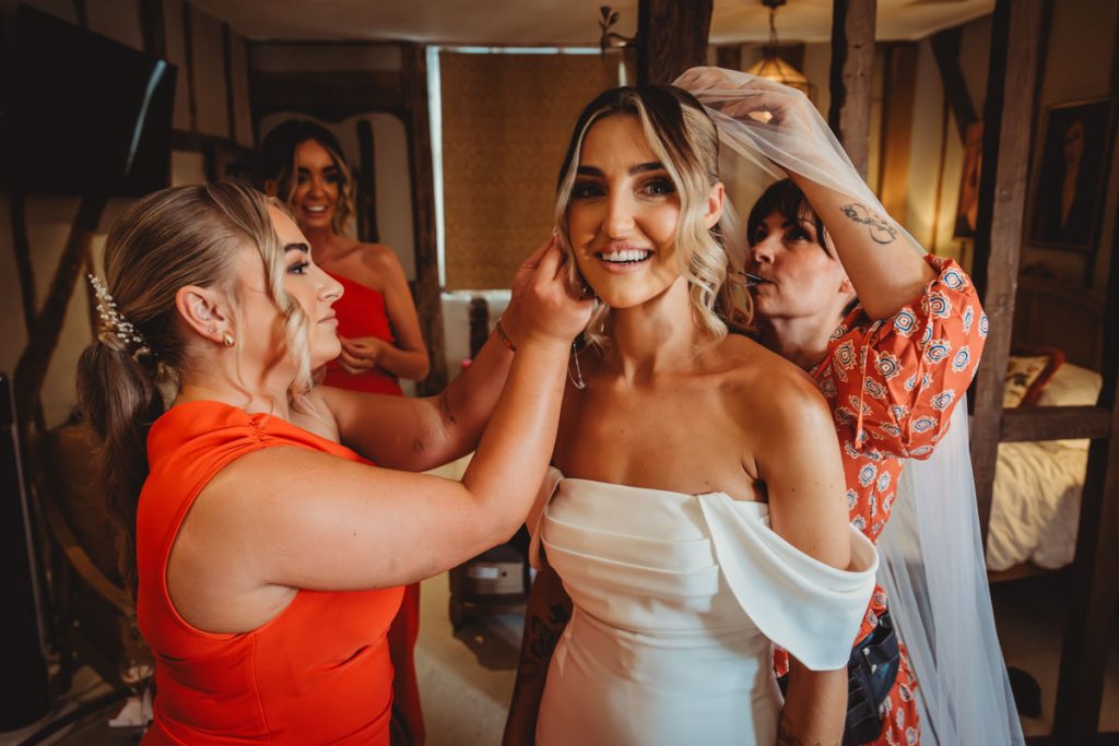 Bride getting ready with bridesmaids' assistance