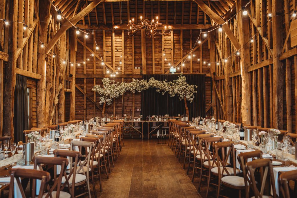 Rustic barn wedding reception with floral decorations.