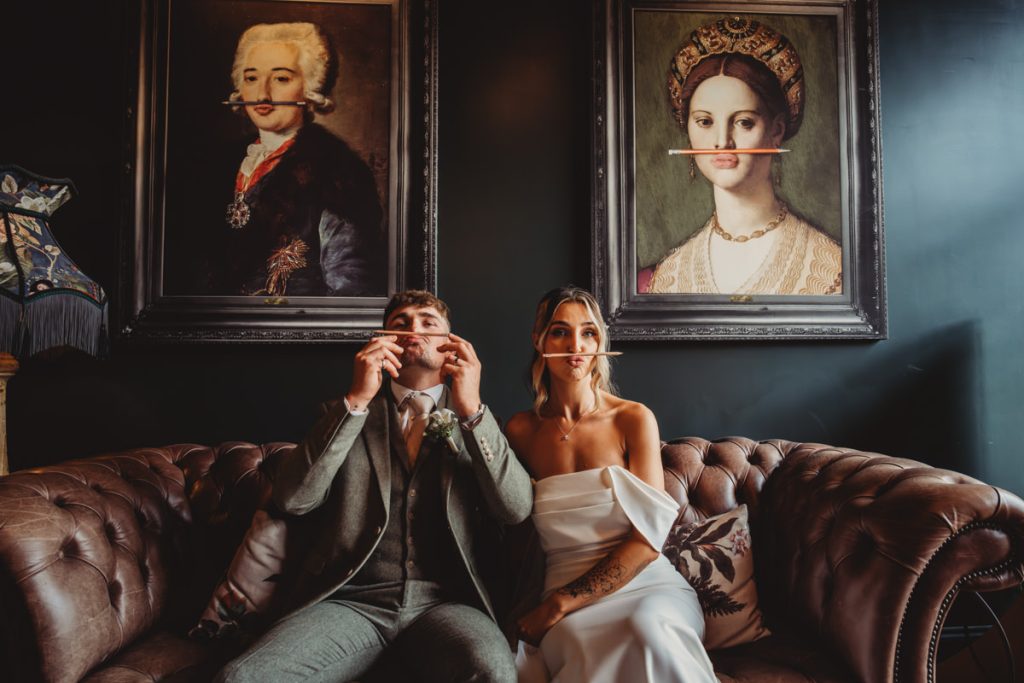 Couple mimicking paintings with straws on upper lips.