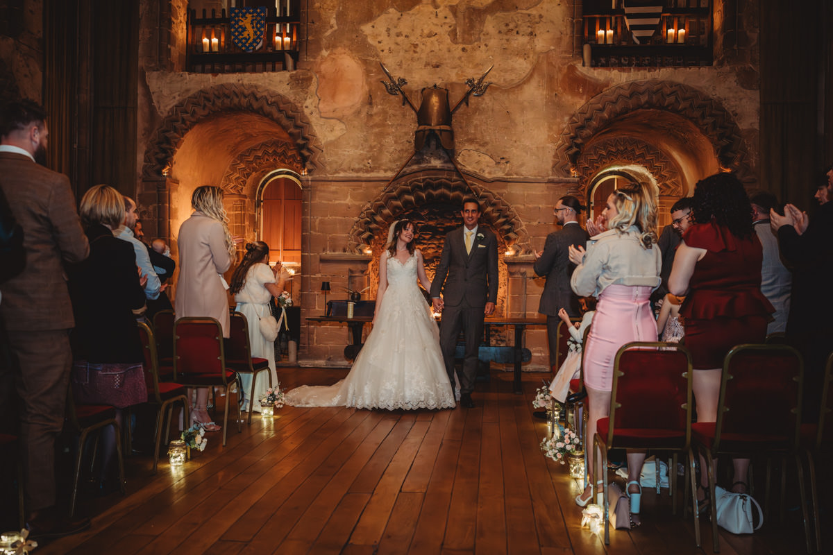 Couple married in candle-lit historic chapel.