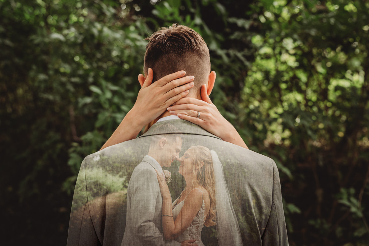 Bride and groom embracing in nature setting.