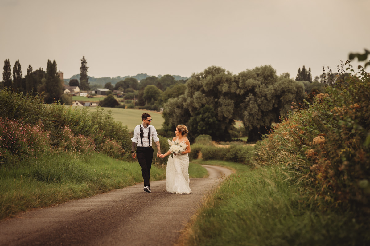 Bride and groom walking on rural path