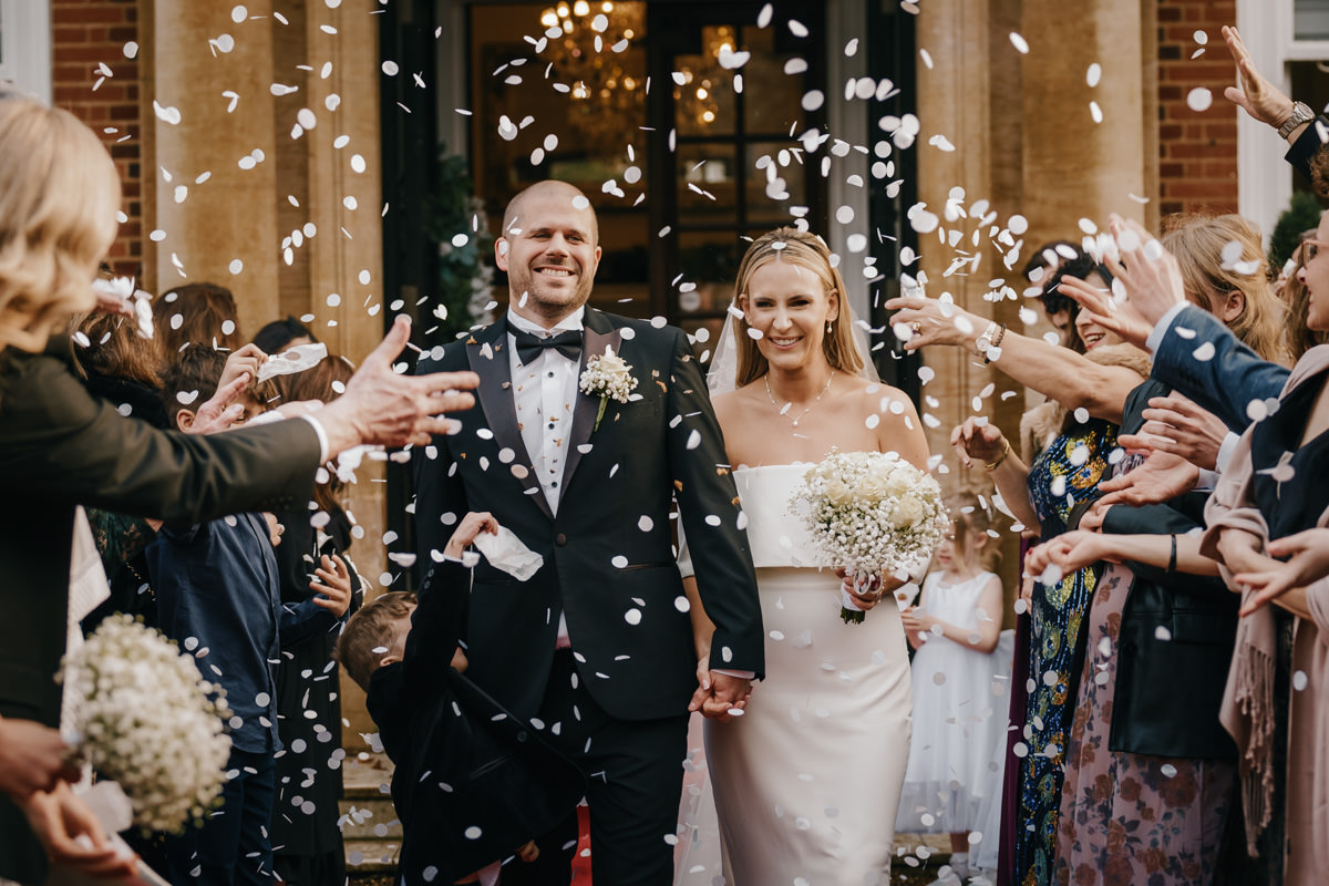 Bride and groom showered with confetti.