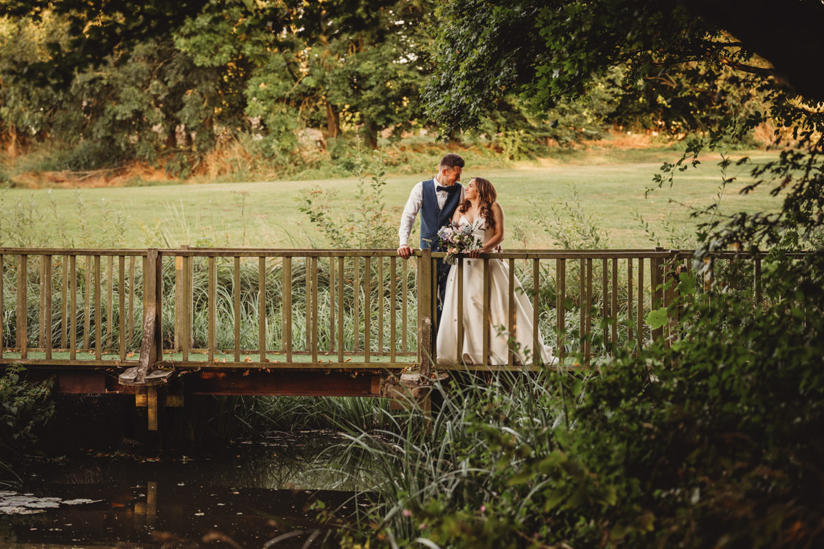 Bride and groom on scenic wooden bridge