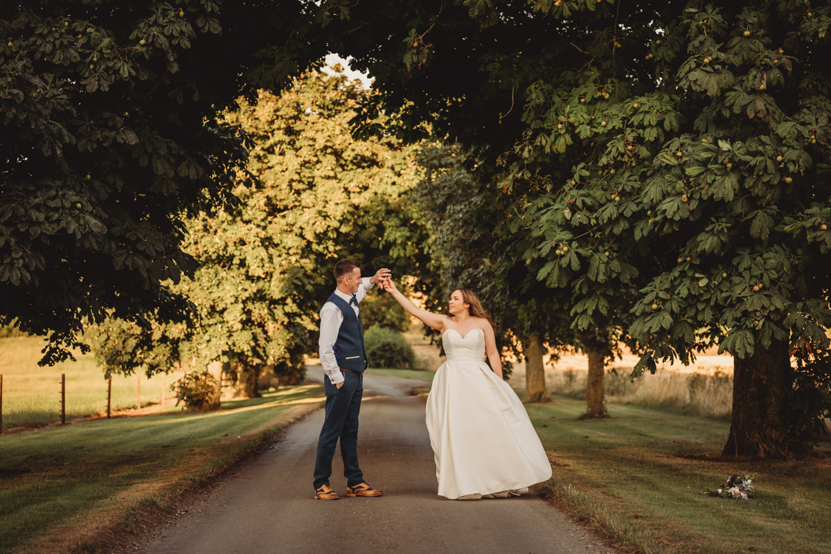 Couple dancing on a tree-lined path