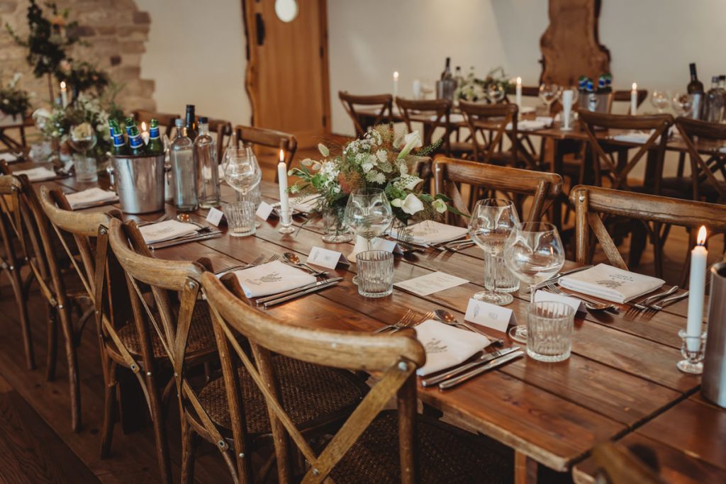 Rustic wedding reception table with candles and flowers.