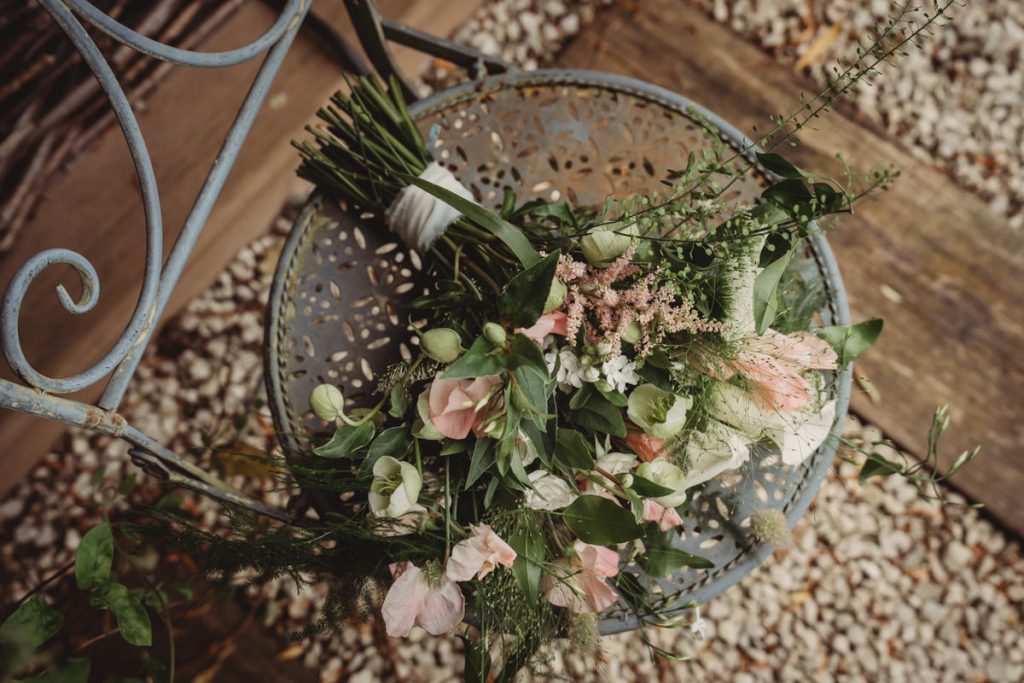 Colourful bouquet on ornate metal chair.