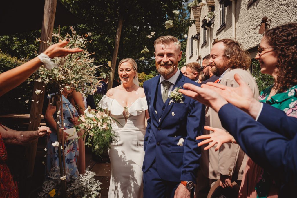 Bride and groom showered with confetti at wedding