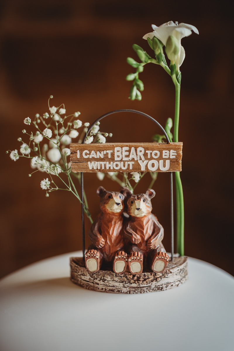 Two bear figurines with love quote and flowers.