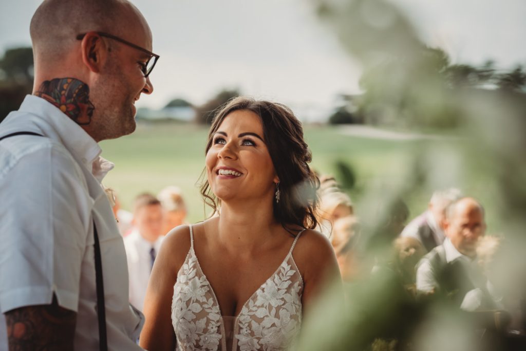 Bride and groom exchanging vows outdoors
