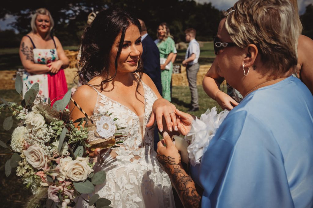 Bride admires ring during outdoor wedding ceremony.