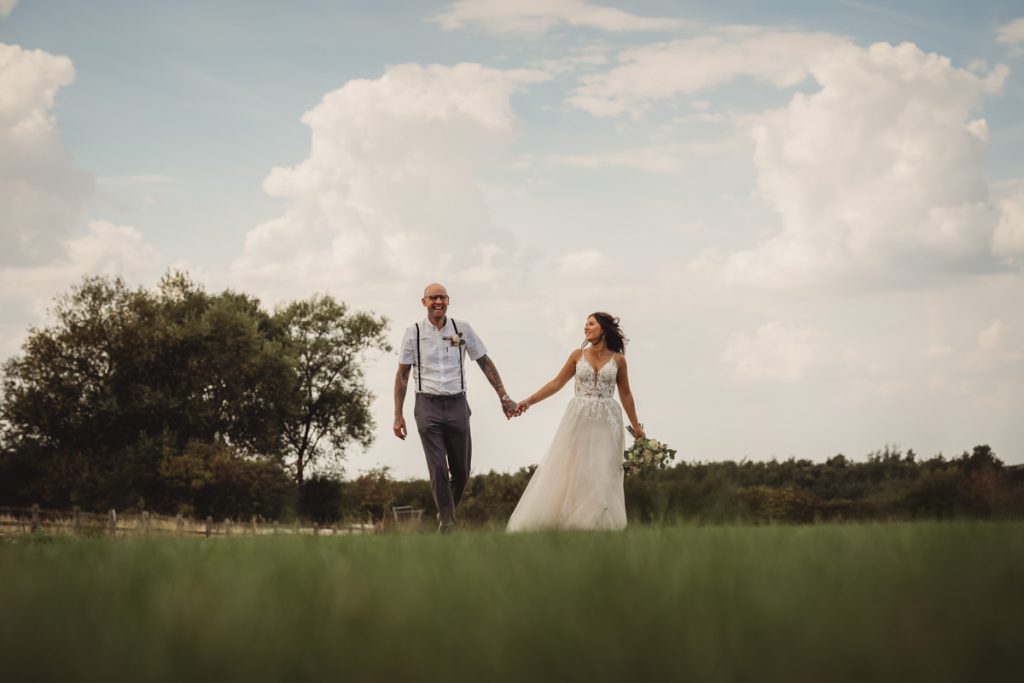 Couple holding hands in a scenic field