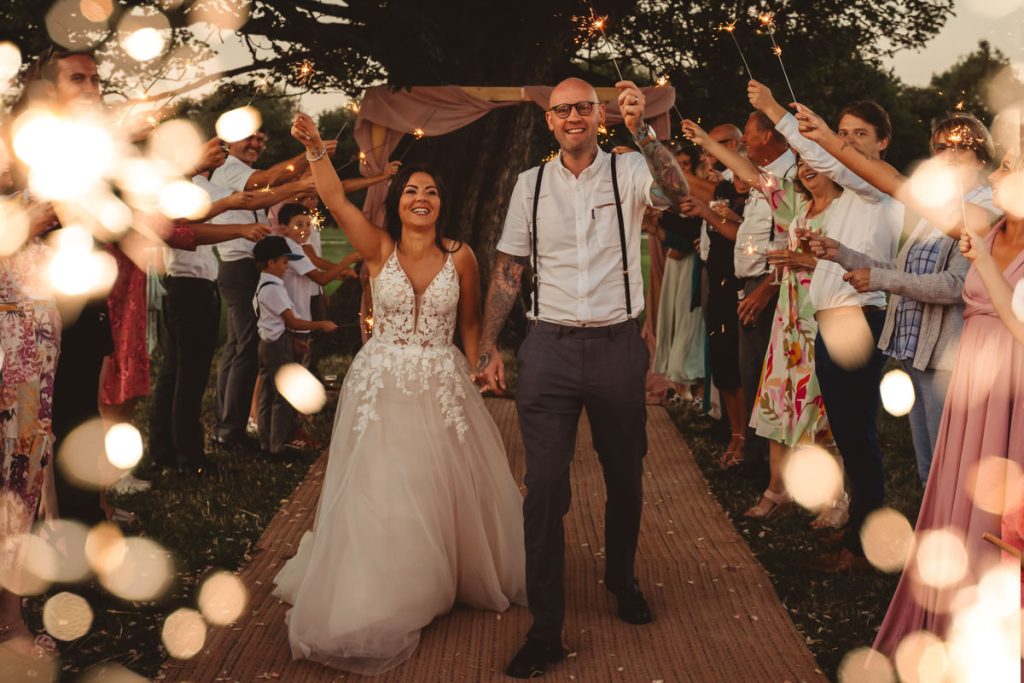 Newlyweds celebrate with sparklers and guests.