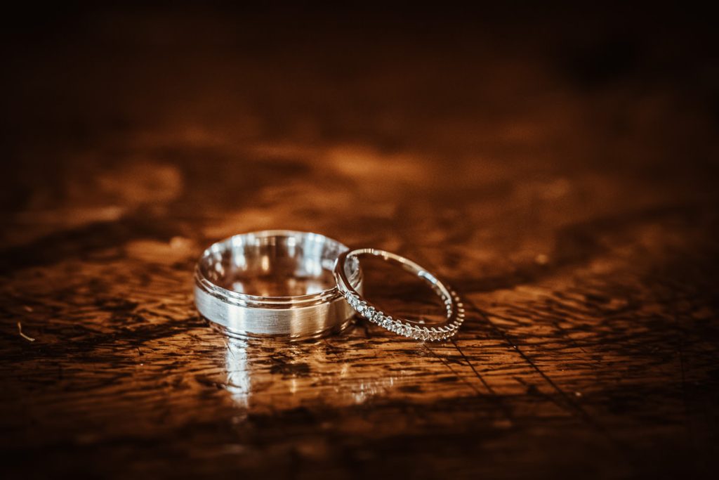Close-up of two wedding rings on wooden table.