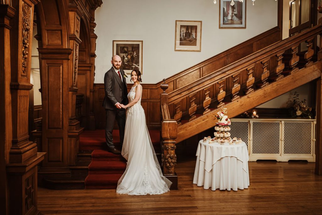Bride and groom at vintage wedding venue staircase.