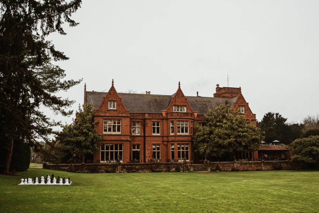 Victorian manor with garden and large chess set.