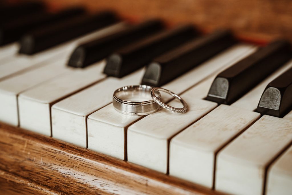 Wedding rings on piano keys symbolising harmony.