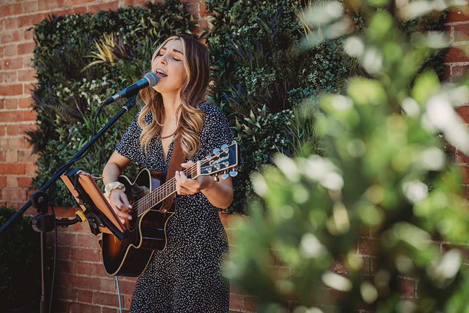 Woman singing and playing guitar outdoors