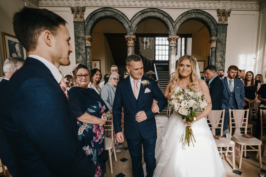 Bride walks down aisle with her father.