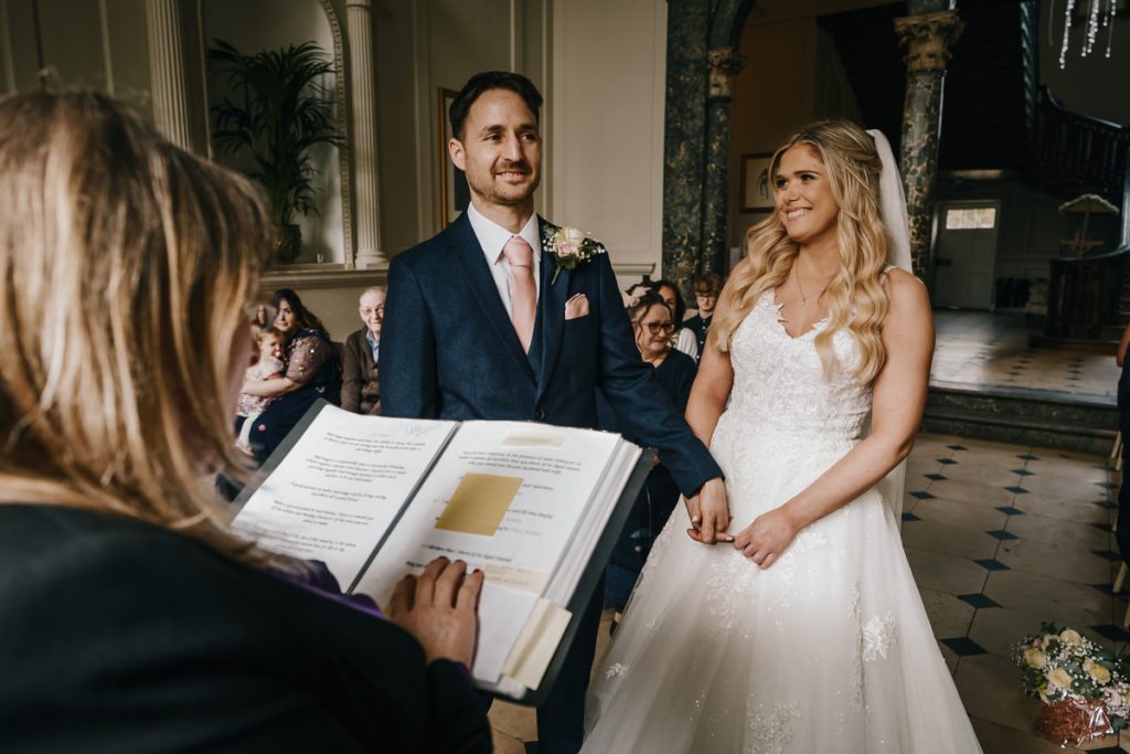 Couple exchanging vows at wedding ceremony indoors.