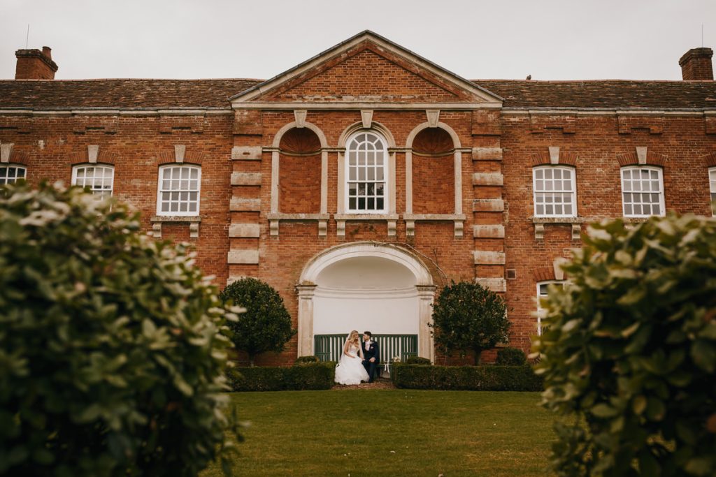 Couple sitting outside historic brick building garden.