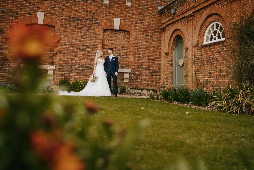 Bride and groom in front of brick building.