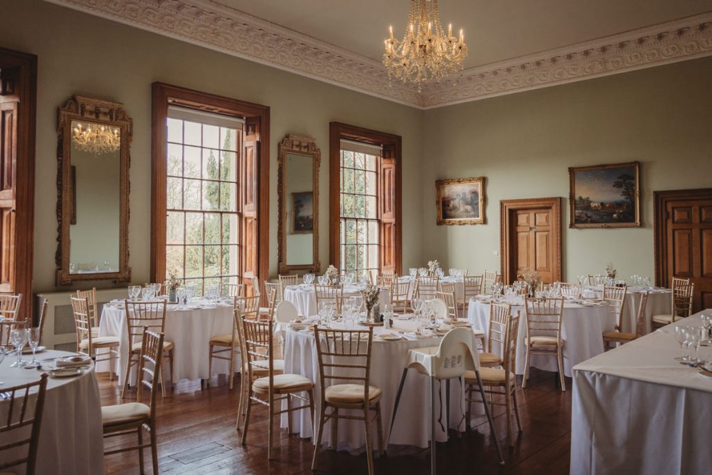 Elegant dining room with round tables and chandelier.