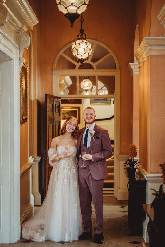 Happy couple celebrating in elegant hallway.