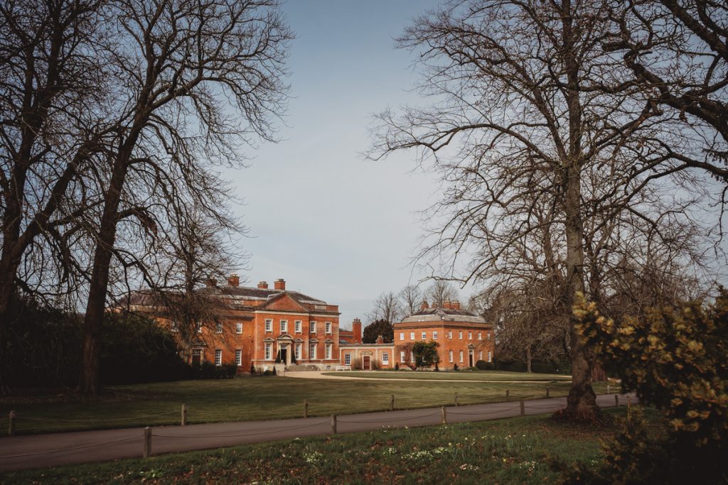 Red brick estate surrounded by trees and lawn
