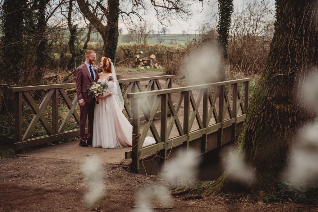 Bride and groom on rustic wooden bridge