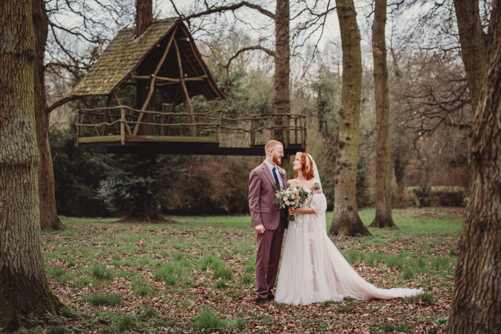 Bride and groom in wooded garden setting.