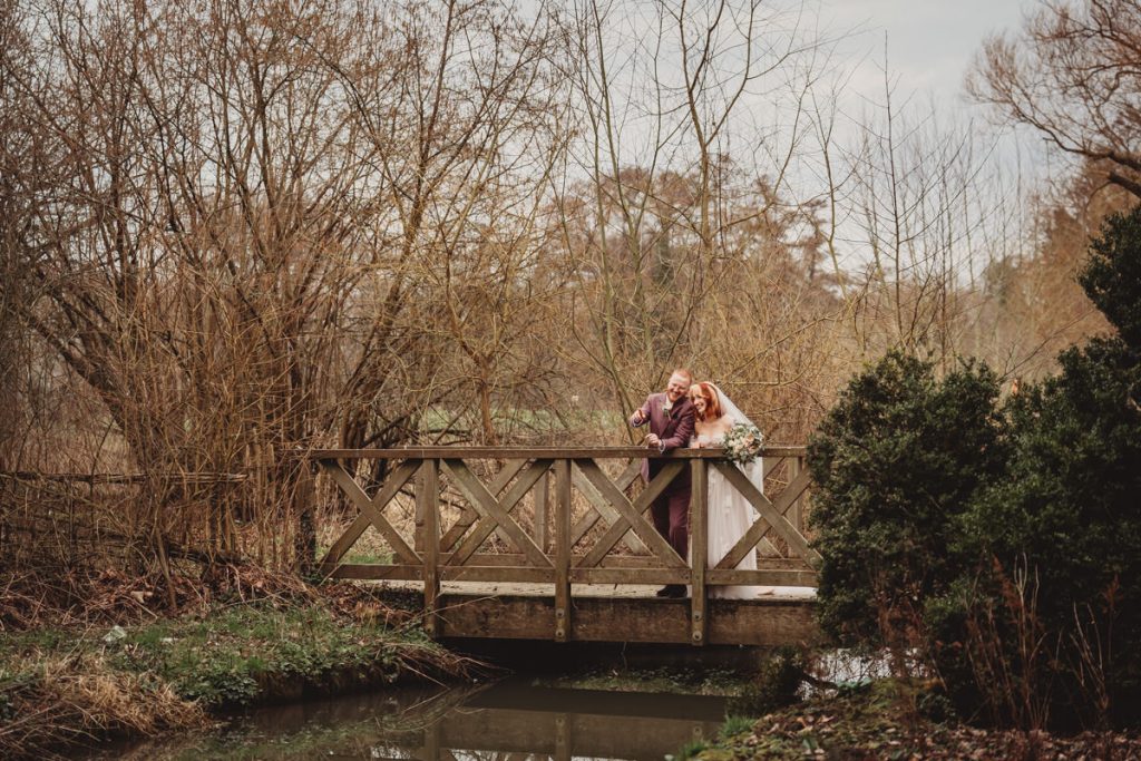 Couple on wooden bridge in winter landscape
