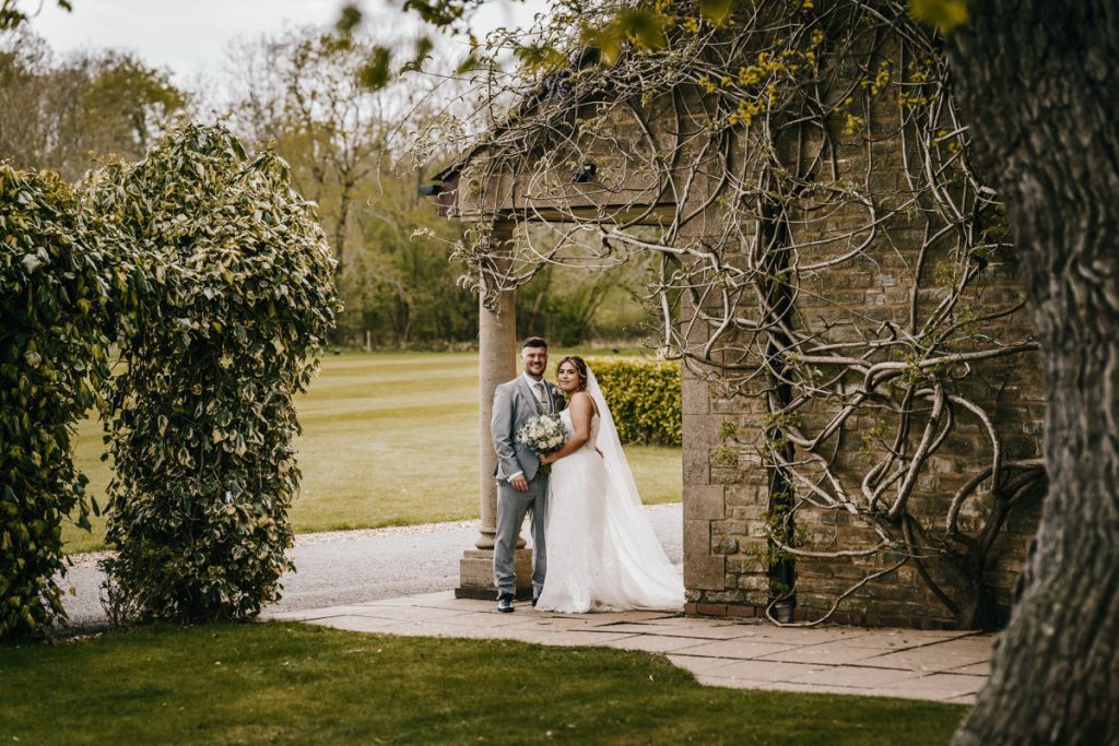 Bride and groom in garden landscape at Whittlebury Park