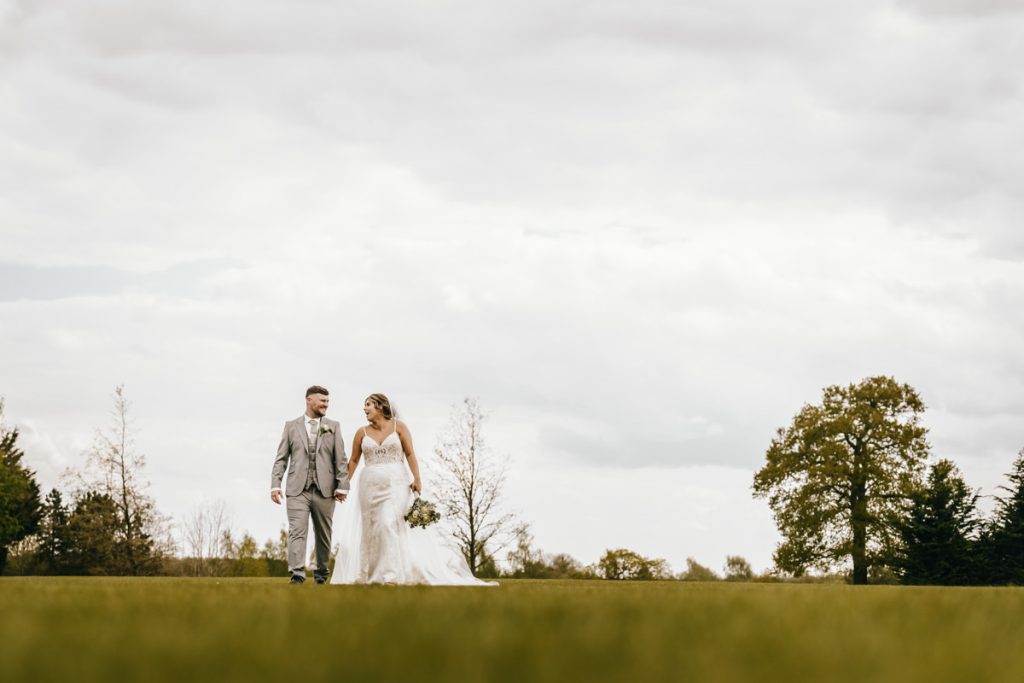 Newlyweds walking in scenic park landscape at Whittlebury Park
