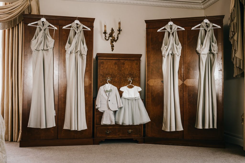Bridesmaid and children's outfits hanging in room at Whittlebury Park