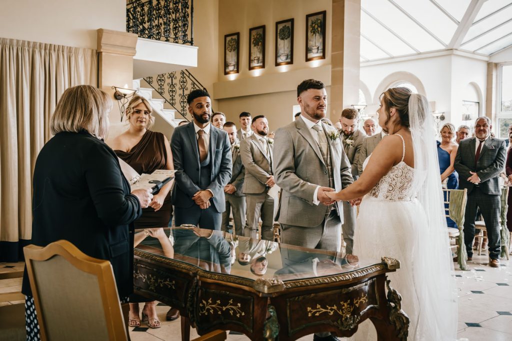 Bride and groom exchanging vows at wedding ceremony at Whittlebury Park